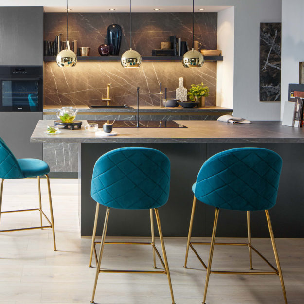 Moderne schwarze Küche mit Granitarbeitsplatte und Nischenrückwand und blau-goldenen Akzenten.