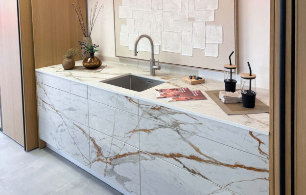 Weiße Arbeitsfläche in Granitoptik mit Holzschränken drumherum.