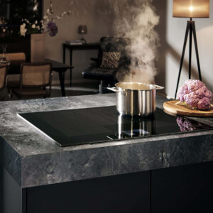 Siemens Induktionskochfeld aus schwarzem Glas mit Topf auf Kochzone, modernes Einbaukochfeld zum schnellen und effizienten Kochen in der Küche