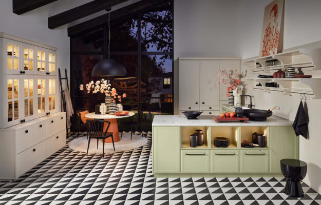 Nolte Landhausküche mit modernen Farbakzenten in Grün und Creme, kombiniert mit offenen Regalen, Kücheninsel und stilvollem Essbereich in wohnlichem Ambiente