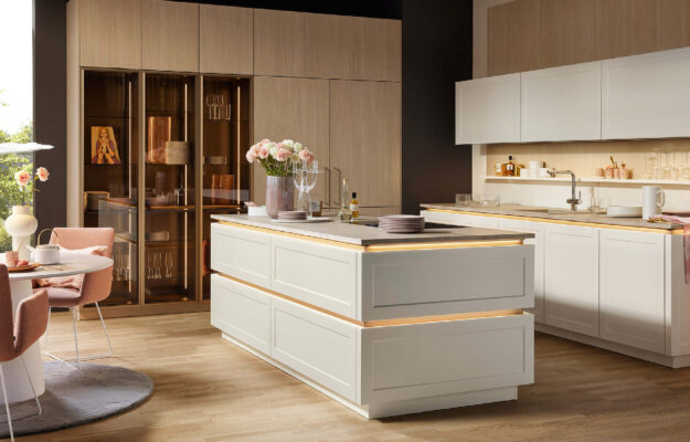 Nolte Luxusküche in heller, eleganter Farbgebung mit großzügiger Kochinsel und integrierter Sitzlösung – perfekt für modernes Wohnen und Genießen.