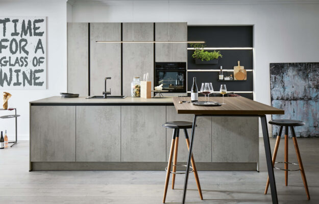Graue grifflose Inselküche von Schüller mit beleuchteten Wandpaneelen und Sitztheke erhältlich bei kitchen concepts